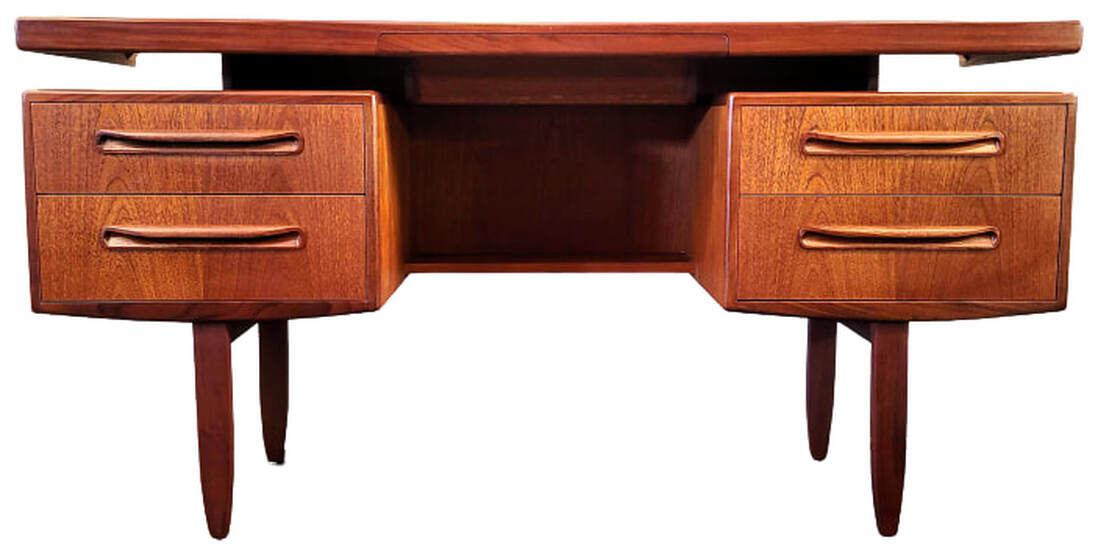 G-Plan New Fresco Dressing Table 2300 makes a great work desk.  Designed by Victor Bramwell (V.B.) Wilkins for Ebenezer Gomme's G-Plan Brand.  This 1977 model is almost identical to the 1967 model number 1982. The original Fresco range launched in November 1966 featured subtle, curved elements. 'New' Fresco is defined by rectilinear lines. The term 'New' was only applied for the first year after launch, reverting thereafter to 'Fresco'.  Desk features teak veneers African afrormosia trim, pulls, and tapered legs.  The frieze drawer in the center of the floating top is lined with purple velvet.  One central shelf is installed at the back of the kneehole.  Each side is fitted with two storage drawers.  Hang a mirror above to use as a bedroom vanity.  60