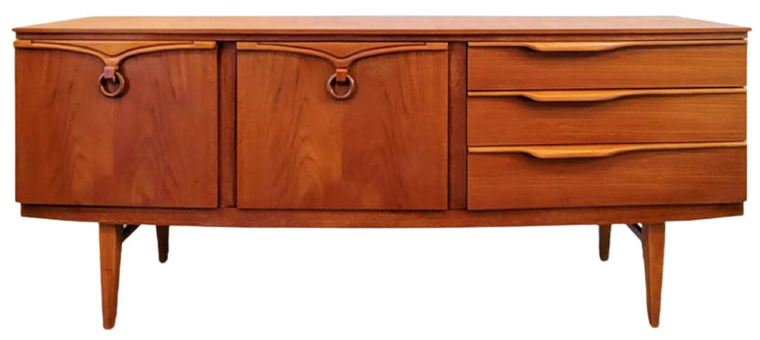 Beautility bow-front sideboard on squared and tapered legs with side stretchers.  The carcase is of new growth teak wood with the door fronts of Southeast Asian crown-cut teak.  On the left is a single door cabinet containing one standard shelf.  In the center is a fall-front cocktail cabinet containing one standard shelf.  On the right are three drawers. The top drawer is lined and contains adjustable spacers for flatware storage.