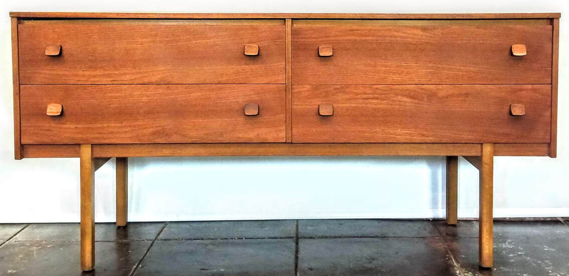 Mid-Century Modern teak dressing table with two drawers on each side, four drawers in all, sitting atop peg legs.
