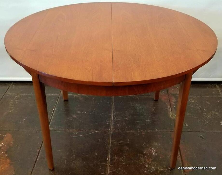 Extendable Round Table - Vintage Danish Modern dining table with Southeast Asian crown-cut teak top and Beech wood legs. Extends to oval with built-in butterfly leaf.