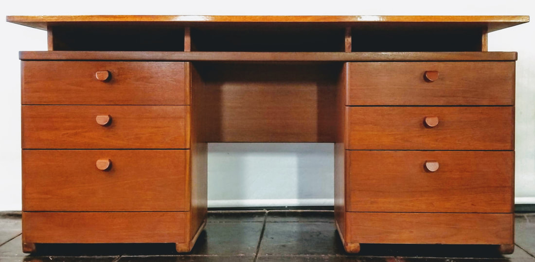Vintage Scandinavian Modern style executive's desk. The top floats above three pigeon holes for storage or keyboards. The desk has six storage drawers, three down each pedestal.